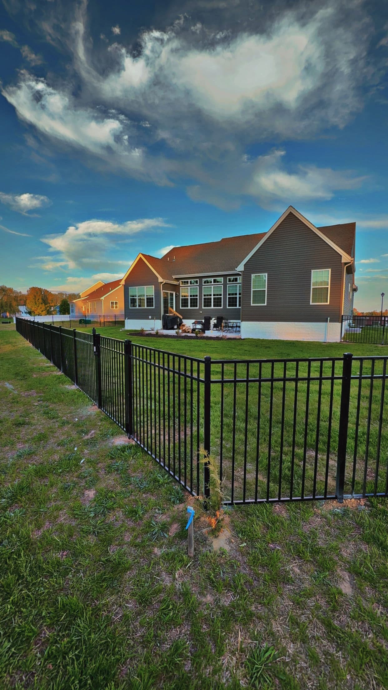 Black Three-Rail Aluminum Fence Installed Around Beautiful Backyard