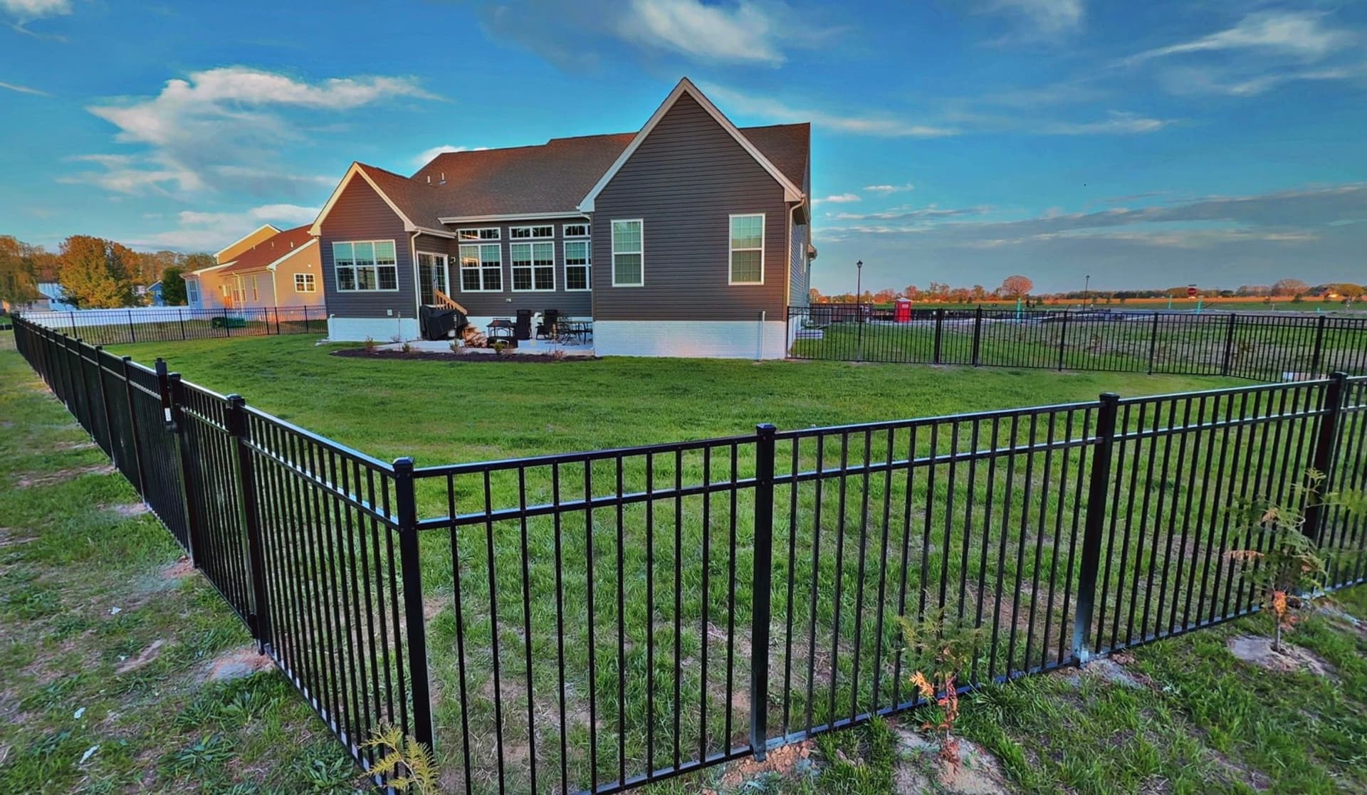 Black Three-Rail Aluminum Fence Installed Around Beautiful Backyard