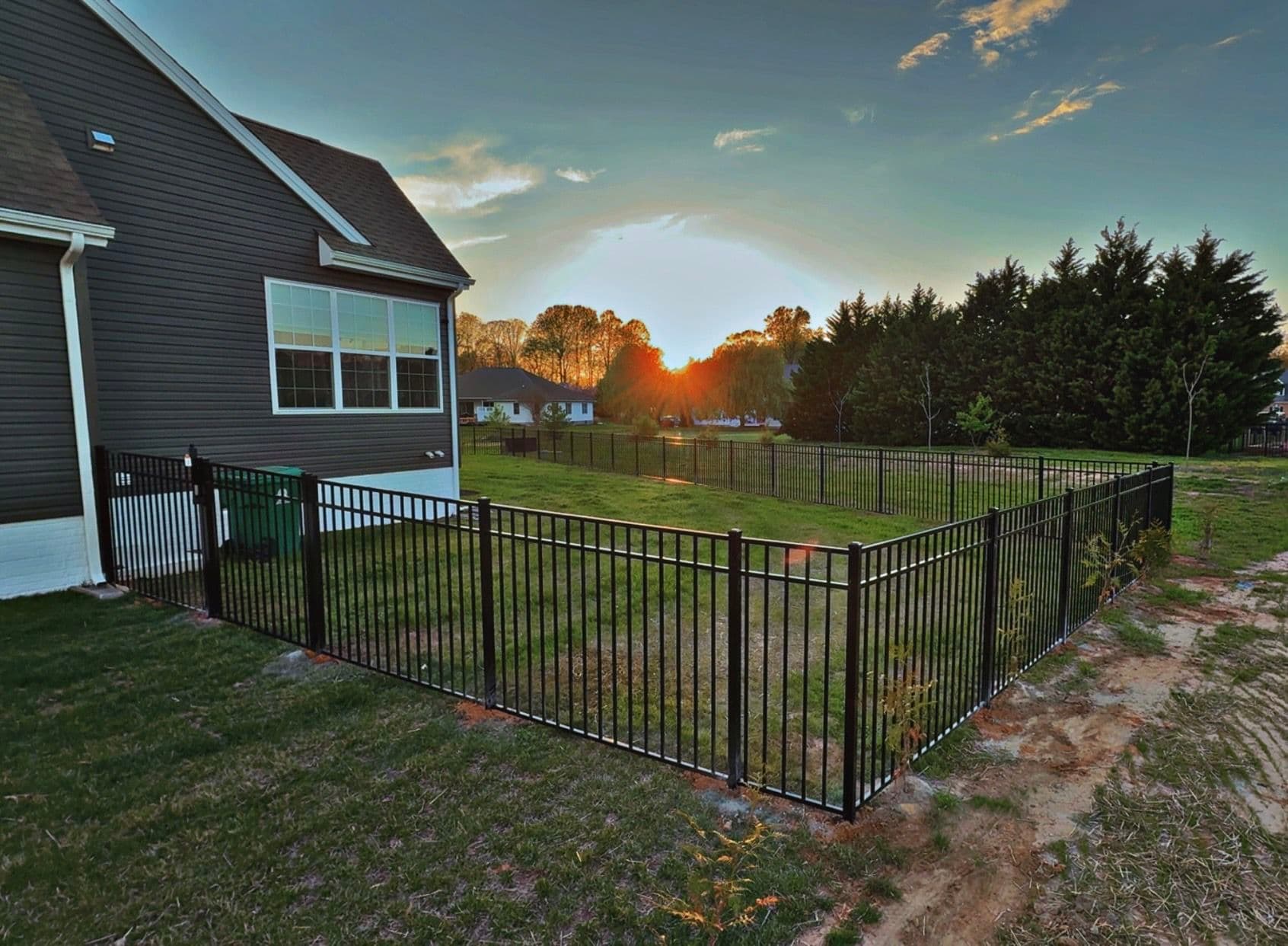 Black Three-Rail Aluminum Fence Installed Around Beautiful Backyard